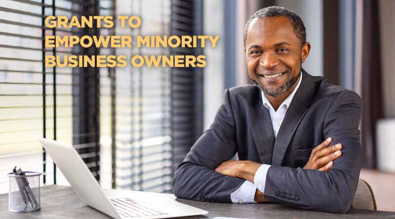 Minority individual sitting at a table in front of their computer.