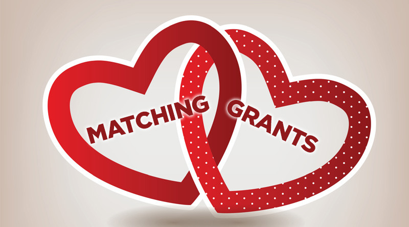 Two red outlines of hearts intertwined with the words Matching Grants inside.